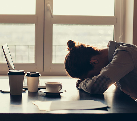 Persona ansiosa sobre escritorio que necesita terapia de ansiedad